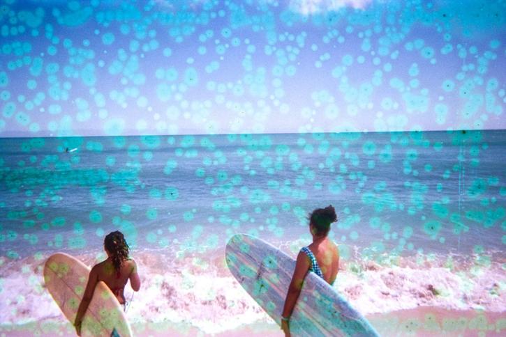 two surfers running to the ocean surfboard in hand photo is marked by light blue dots